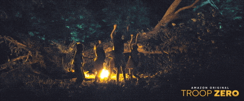 Pre-teen girls dance by a campfire in a scene from Troop Zero