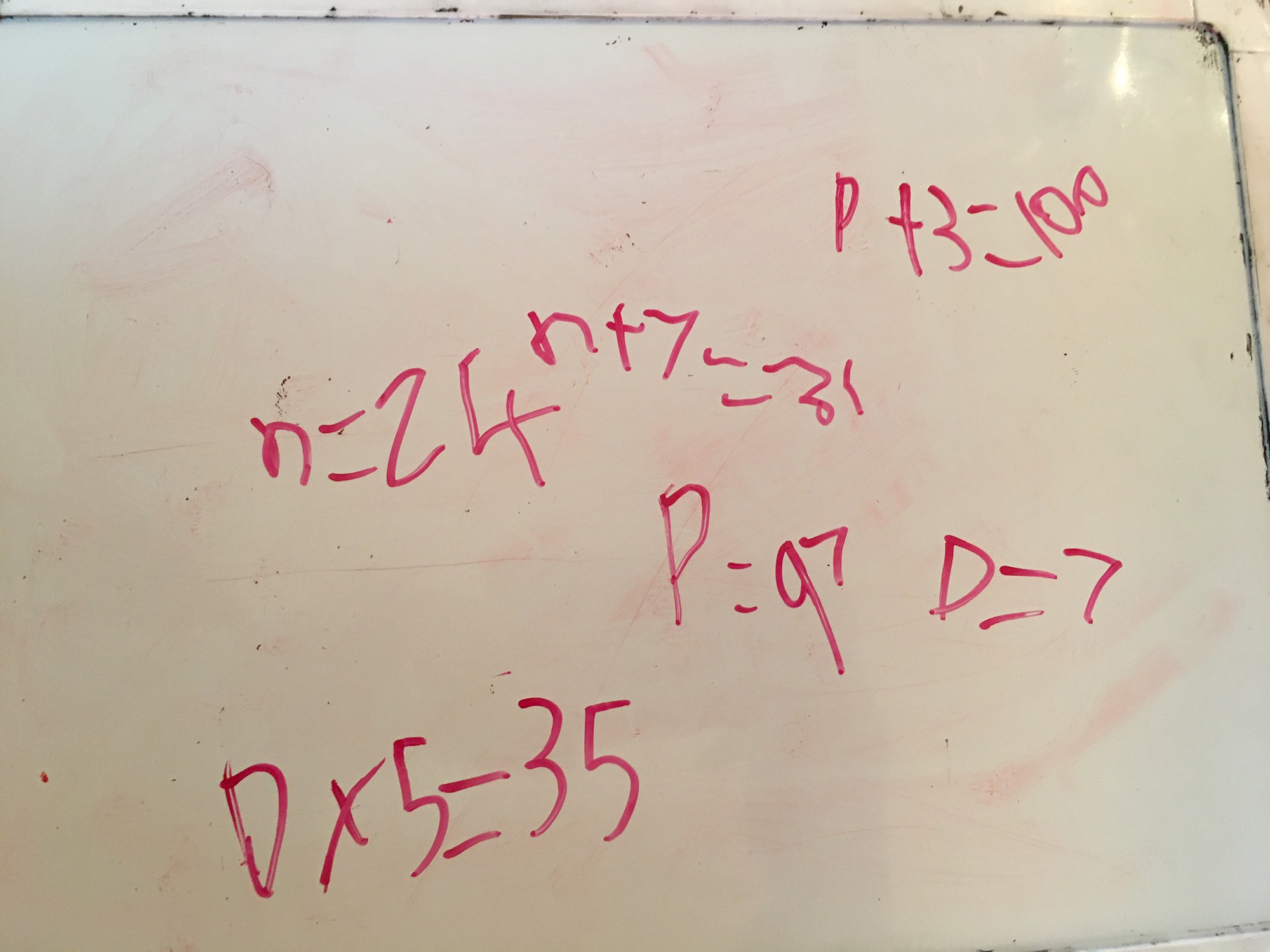 Equations written on a small white dry erase board.
