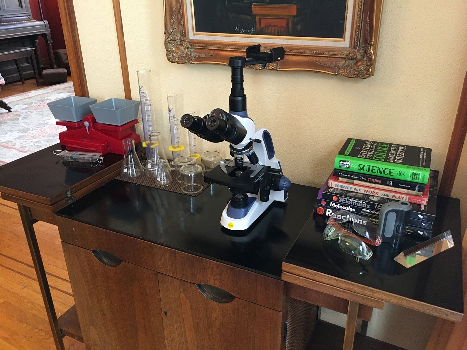 A vintage 1960s cocktail cart, topped with our microscope, glassware, scales, and science books.