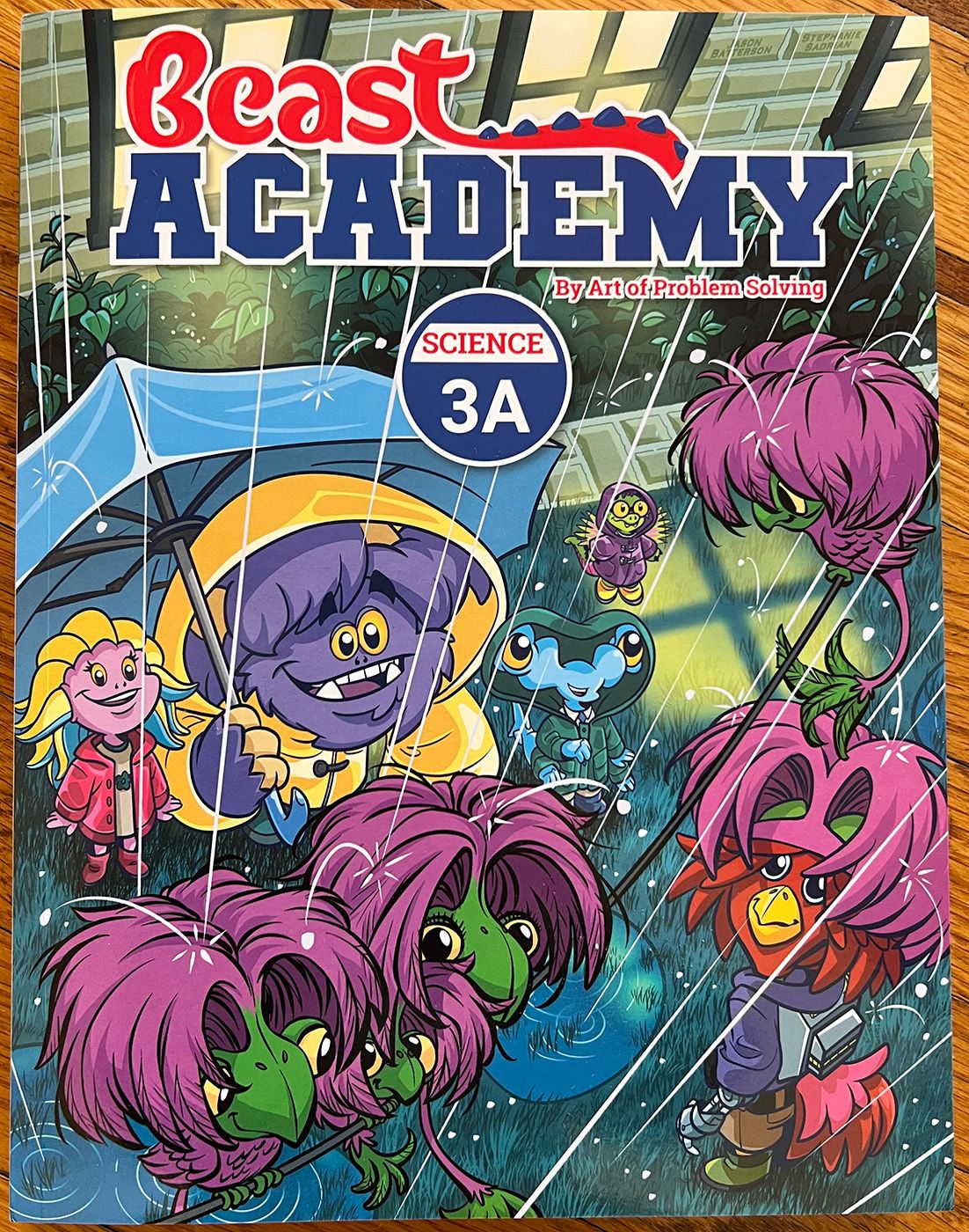 The cover of Beast Academy Science 3A, with four cartoon beasts smiling in a hail storm.