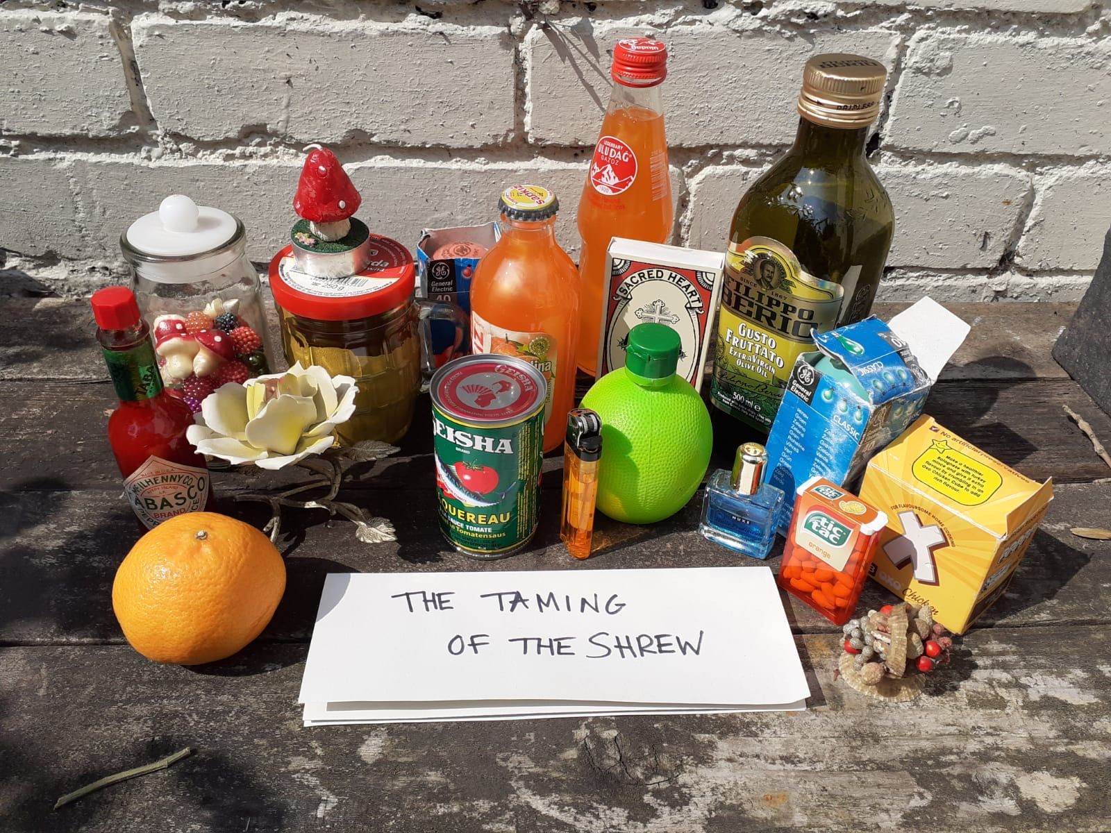 A collection of ordinary household items, plus a handwritten slip of paper saying, "The Taming of the Shrew"