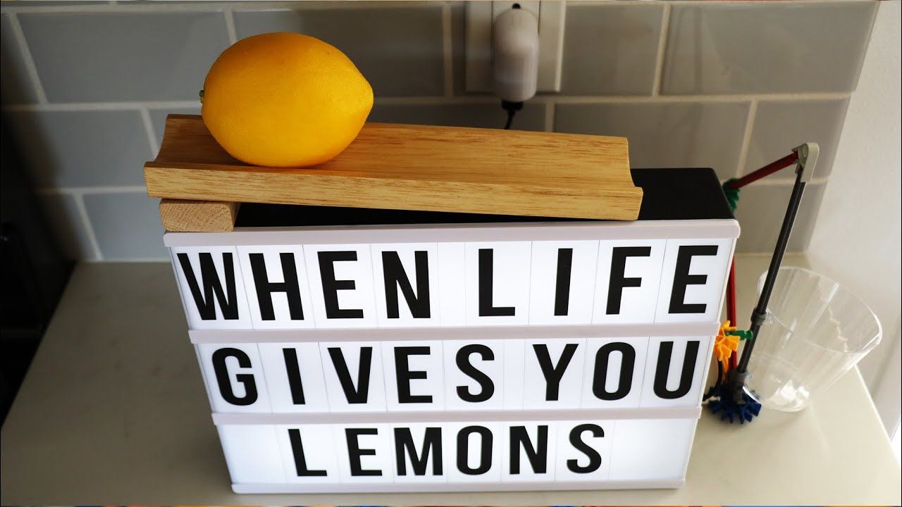 Sign that says "When life gives you lemons," topped with a lemon at the top of a ramped chute.