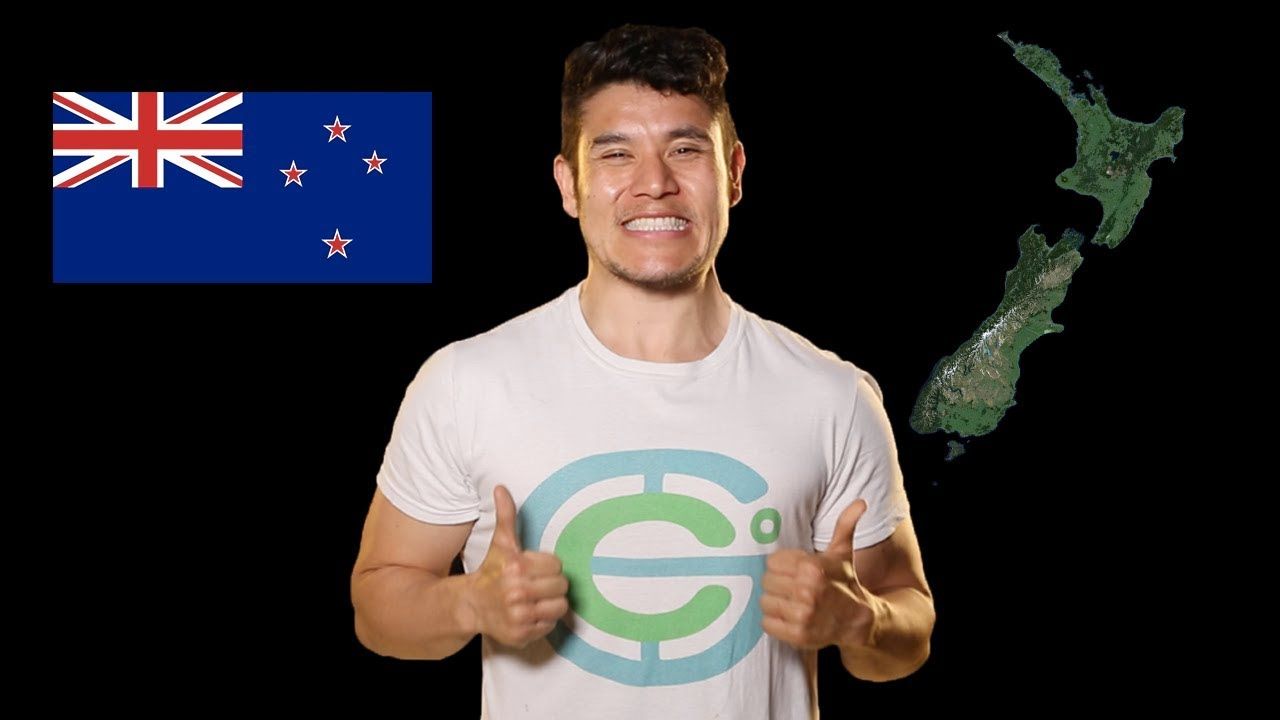 Man standing and smiling alongside a satellite view of New Zealand and the New Zealand flag.