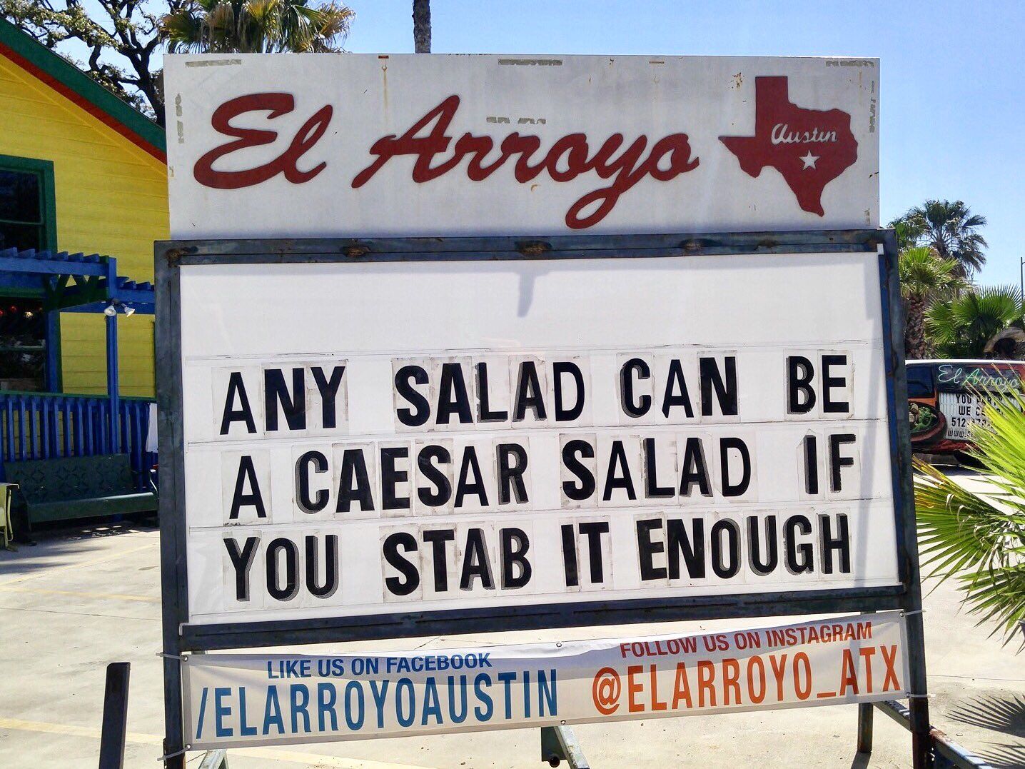 A sign saying "ANY SALAD CAN BE A CAESAR SALAD IF YOU STAB IT ENOUGH"