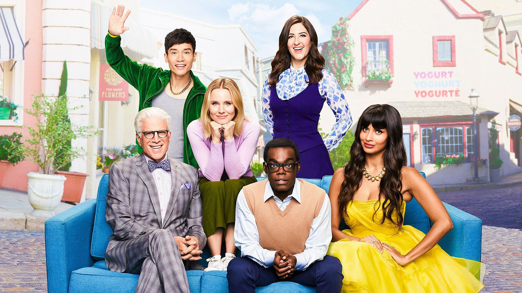 The cast of the TV show The Good Place are seated on a couch in the town square of the afterlife.