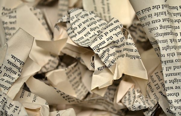 Crumpled pages torn from printed books